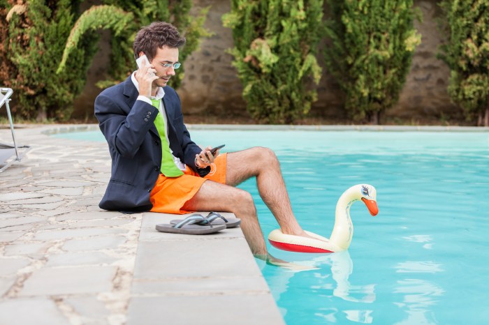 Funny Young Businessman with SwimmingTrunks next to the Pool