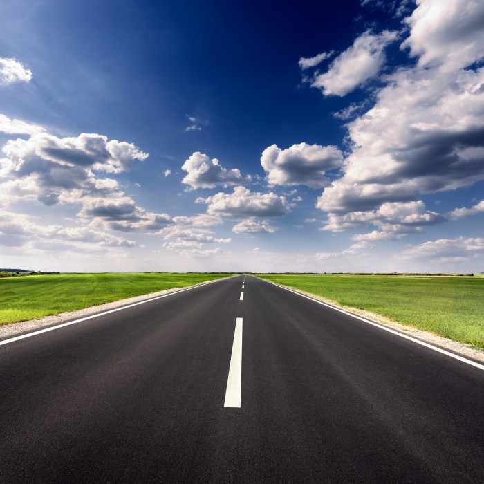 Driving on empty asphalt road at idyllic sunny day