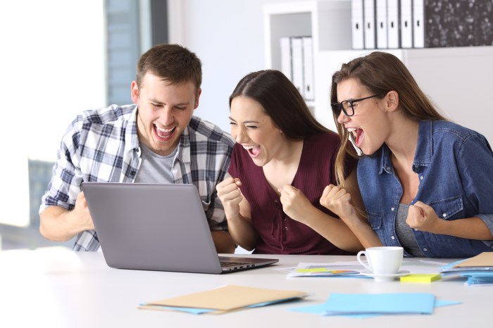 Excited employees reading good news at office